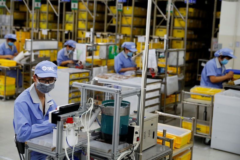 &copy; Reuters. FILE PHOTO: Employees wearing face masks work at a factory of the component maker SMC during a government-organized tour of its facility following the outbreak of the coronavirus disease (COVID-19), in Beijing, China May 13, 2020. REUTERS/Thomas Peter