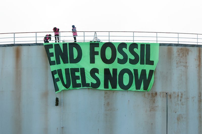 &copy; Reuters. Extinction Rebellion activists hang a sign on a storage tank at Esso West London Terminal, in Staines, Britain April 1, 2022. REUTERS/John Sibley