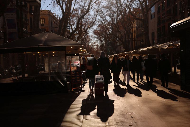 &copy; Reuters. FILE PHOTO: Tourists walk in the winter sun on Las Ramblas, amid the outbreak of the coronavirus disease (COVID-19), as the Spanish government considers the sixth wave of COVID-19 to be coming to an end, in Barcelona, Spain February 1, 2022. Picture taken