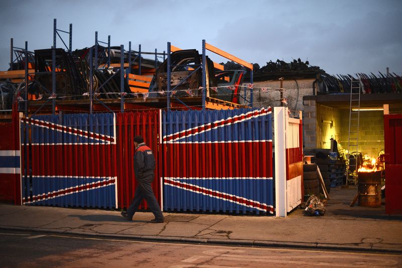 &copy; Reuters. FILE PHOTO: A man walks past a car scrap yard in east London January 25, 2013. REUTERS/Paul Hackett