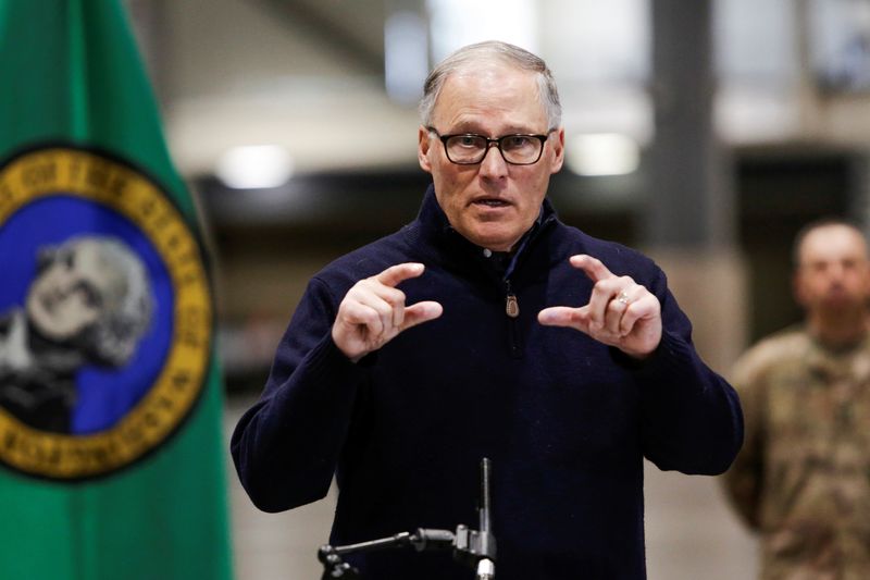 &copy; Reuters. FILE PHOTO: Washington Governor Jay Inslee asks people to place a photo of a first responder on their car's dashboard and ask themselves each time they go out, is it worth risking that person's life to leave their home, during a press conference at the Ce