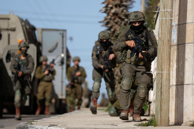 © Reuters. جنود إسرائيليون خلال مداهمة في رام الله بالضفة الغربية يوم الجمعة. تصوير: محمد تركمان - رويترز.