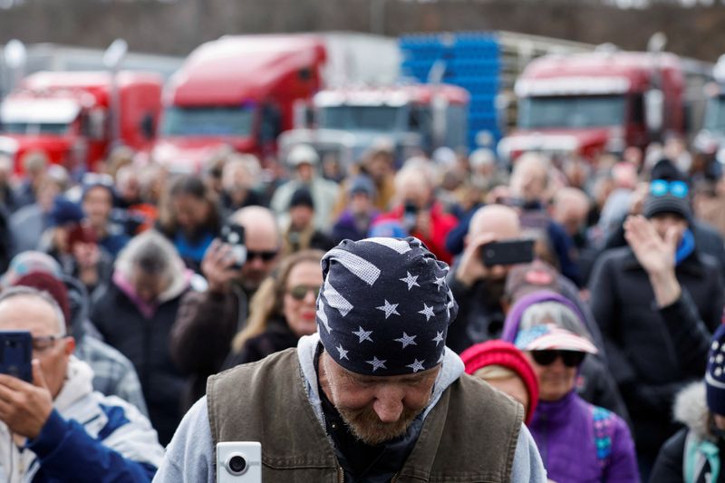 © Reuters. People bow their heads in prayer as part of a rally at Hagerstown Speedway held by activists from a convoy that traveled across the country headed to Washington D.C. to protest coronavirus disease (COVID-19) related mandates and other issues in Hagerstown, Maryland, U.S. March 26, 2022.  Picture taken March 26, 2022. REUTERS/Jonathan Ernst