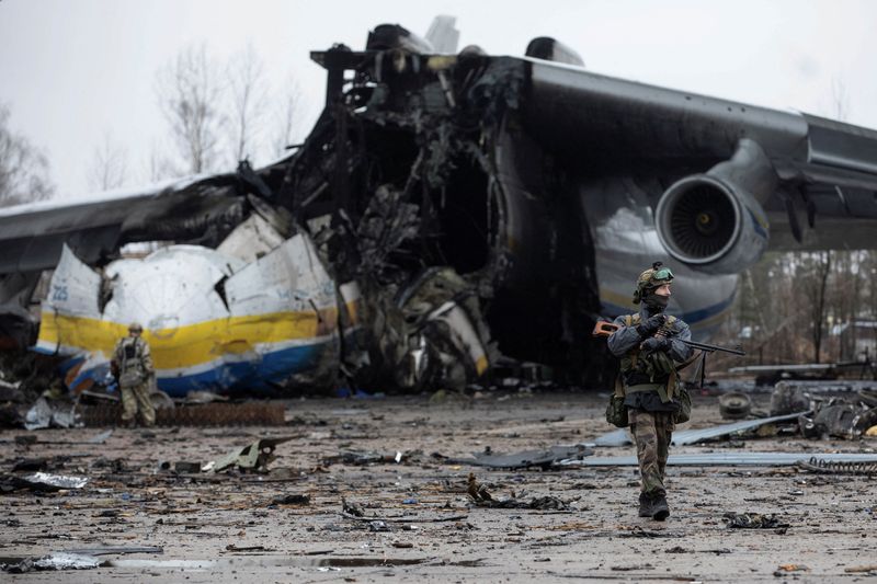 © Reuters. Un miembro del servicio ucraniano camina delante del avión de carga Antonov An-225 Mriya, el más grande del mundo, destruido por las tropas rusas en medio del ataque de Rusia a Ucrania, en un aeródromo en el asentamiento de Hostomel, en la región de Kiev, Ucrania. 2 de abril de 2022.  REUTERS/Mikhail Palinchak  