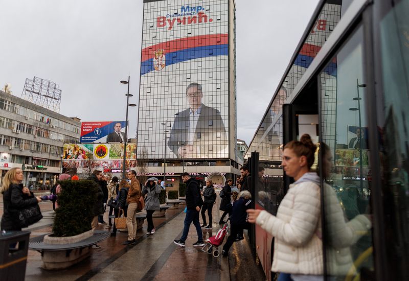 &copy; Reuters. FILE PHOTO: People walk by a huge election campaign billboard featuring Aleksandar Vucic on the hotel Ambasador, the presidential candidate of the ruling SNS party (Serbian Progressive Party) in Nis, Serbia, April 1, 2022. REUTERS/Antonio Bronic