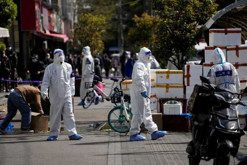 &copy; Reuters. FILE PHOTO: Police and security members in protective suits stand outside cordoned off food stores following the coronavirus disease (COVID-19) outbreak in Shanghai, China March 29, 2022. REUTERS/Aly Song/File Photo