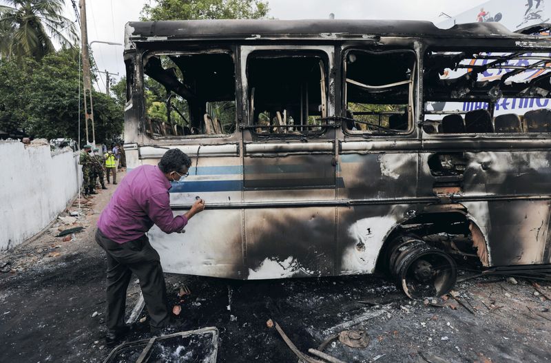 &copy; Reuters. FILE PHOTO: Sri Lankan crime scene officer inspects the finger prints on the bus after it was set on fire by demonstrators at the top of the road to Sri Lankan President Gotabaya Rajapaksa's residence during a protest against him, as many parts of the cri