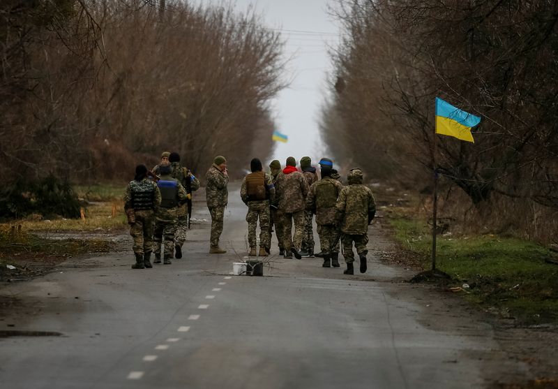 &copy; Reuters. جنود أوكرانيون يسيرون بالقرب من العلم الأوكراني في العاصمة الأوكرانية كييف يوم السبت. تصوير: جليب جارانيش - رويترز.
