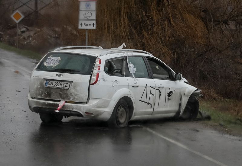 &copy; Reuters. Un coche baleado con inscripciones "Niños" se ve en la calle, en medio de la invasión rusa a Ucrania, en Bucha, región de Kiev, Ucrania. 3 de abril de 2022. REUTERS/Gleb Garanich