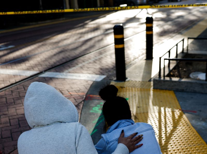 © Reuters. شخصان في حالة انهيار في موقع اطلاق النار في سكرامنتو بكاليفورنيا يوم الأحد. تصوير:رويترز.