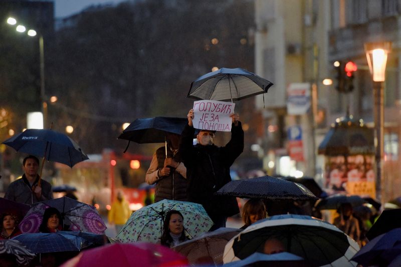 © Reuters. رجل يحمل لافتة خلال مسيرة لتحالف 