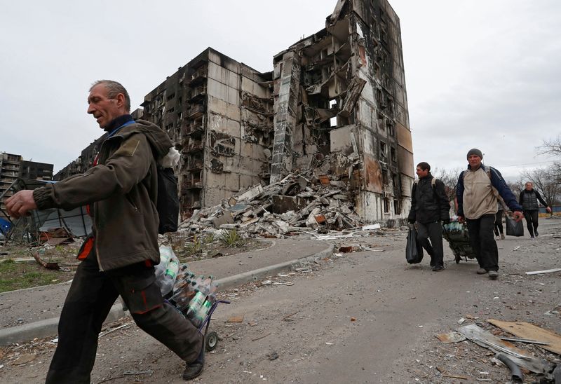 &copy; Reuters. Local residents walk past a building destroyed during Ukraine-Russia conflict in the southern port city of Mariupol, Ukraine April 3, 2022. REUTERS/Alexander Ermochenko