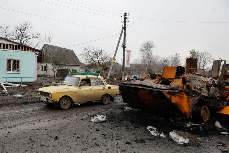 &copy; Reuters. ساكن محلي يقود سيارته بجانب مدرعة روسية مدمرة مع استمرار القصف الروسي الأوكراني في منطقة تشيرنيهيف يوم الأول من أبريل نيسان 2022. تصوير: سيرهي