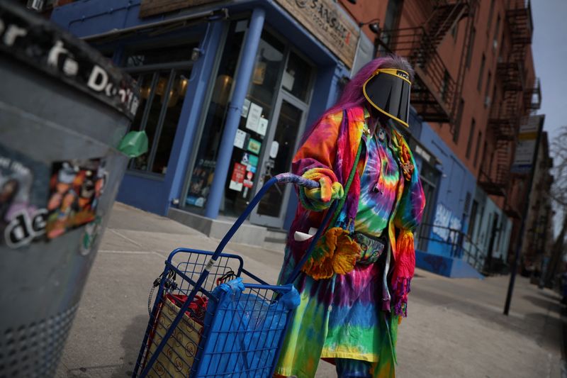© Reuters. A woman walks wearing a protective face mask on a street corner on the Lower East Side of New York City, U.S., April 4, 2022.  REUTERS/Shannon Stapleton