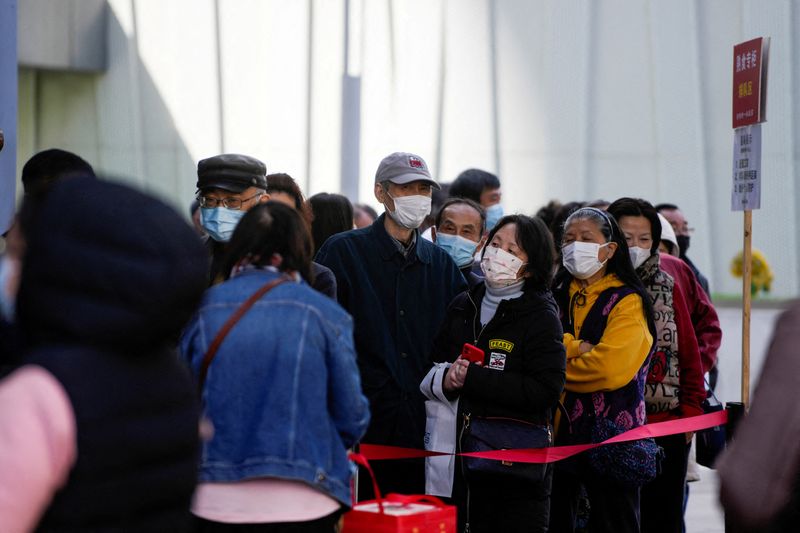 &copy; Reuters.   ４月５日、中国上海市では新型コロナウイルスの無症状感染者が新たに１万３０８６人確認された。症状がある感染者も２６８人報告された。写真は３月２９日、上海の食料品店で行列す