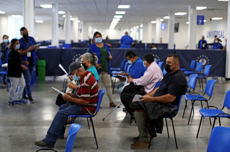 &copy; Reuters. People wait to receive a dose of Pfizer-BioNTech coronavirus disease (COVID-19) vaccine at a vaccination center as the Salvadoran government authorized a fourth dose of the vaccine in San Salvador, El Salvador, March 22, 2022. REUTERS/Jose Cabezas