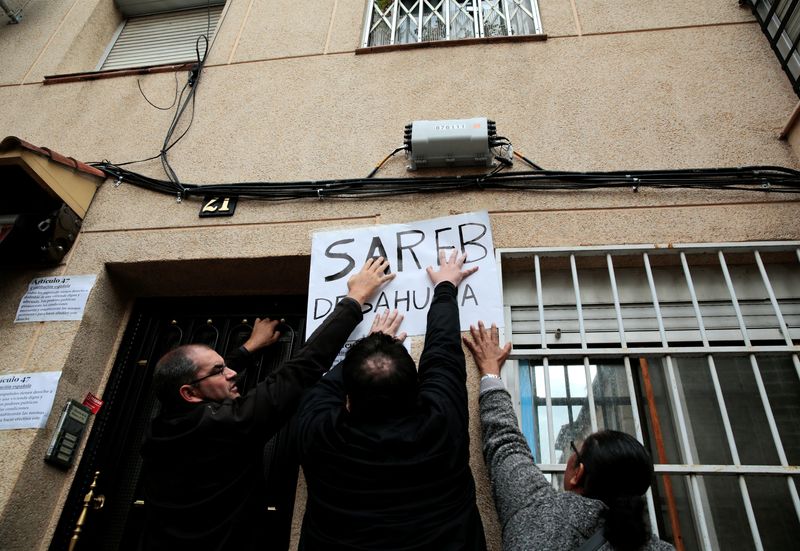 &copy; Reuters. FILE PHOTO: Anti-eviction activists stick a banner reading "Sareb evicts" against a wall as they wait for an eviction in Madrid, Spain, October 14, 2016.  REUTERS/Andrea Comas/File Photo