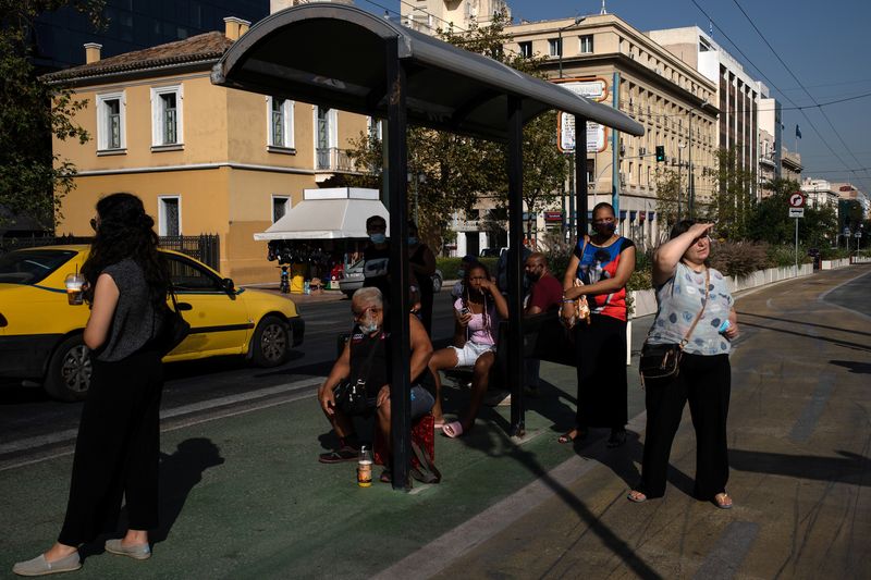 &copy; Reuters. FILE PHOTO: Commuters wait at a bus stop in Athens, Greece, September 3, 2020. REUTERS/Alkis Konstantinidis