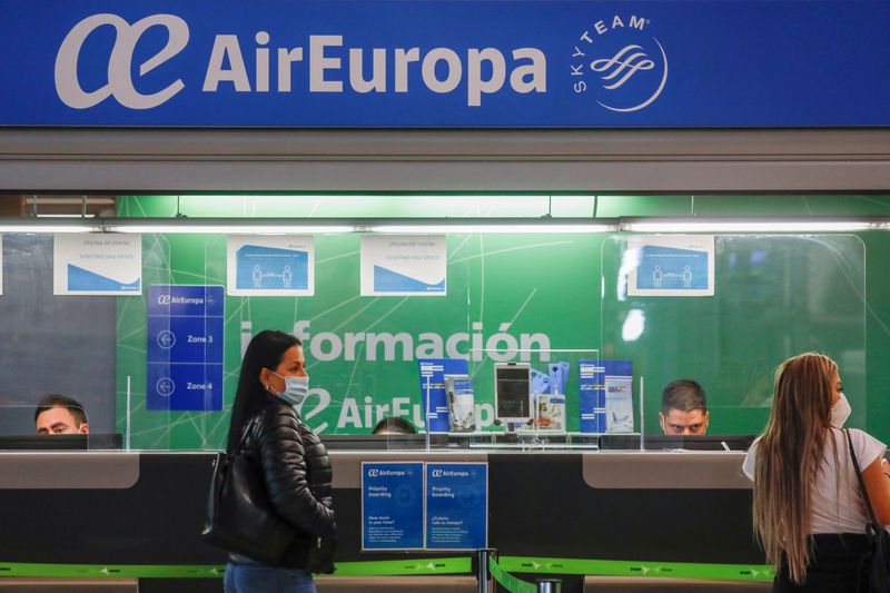 &copy; Reuters. FILE PHOTO: Passengers wearing face masks stand at an Air Europa customer service booth at Adolfo Suarez Barajas airport amid the coronavirus disease (COVID-19) pandemic in Madrid, Spain, December 15, 2020. REUTERS/Susana Vera