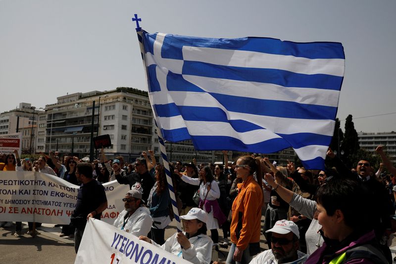 © Reuters. A woman holds a Greek flag as she takes part in a protest during a 24-hour strike over high prices and low wages in Athens, Greece, April 6, 2022. REUTERS/Costas Baltas