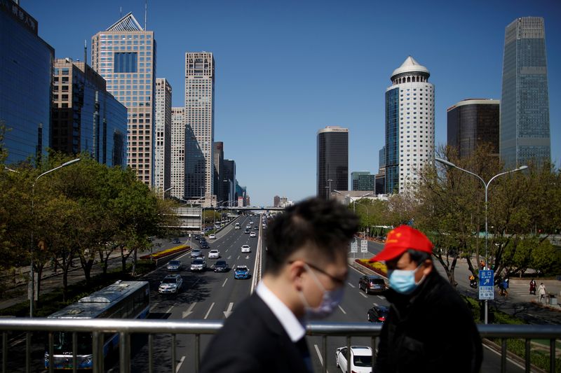 &copy; Reuters. People wearing protective masks cross a bridge at the Central Business District on a “blue sky day" in Beijing, as the spread of the novel coronavirus disease (COVID-19) continues, in China  April 22, 2020. REUTERS/Thomas Peter