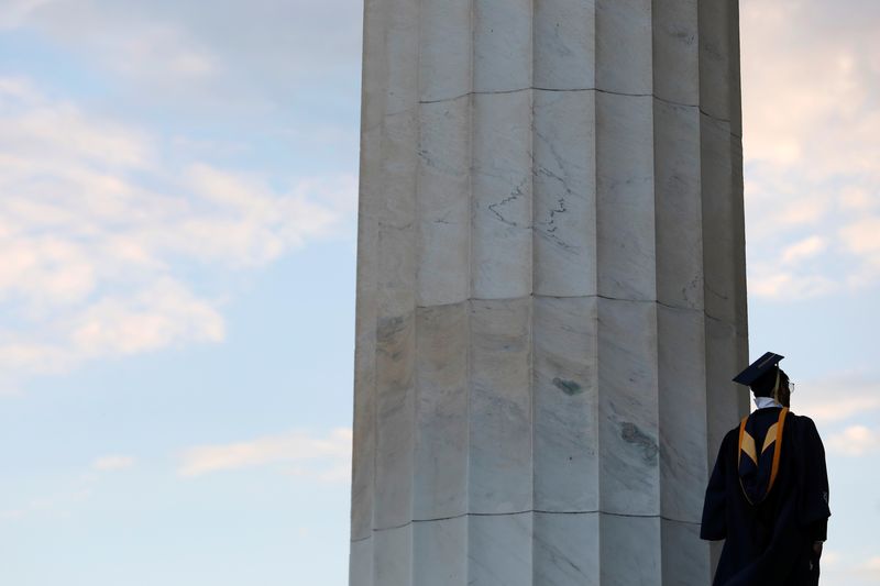 &copy; Reuters. FILE PHOTO: A person in graduation regalia stands on the Lincoln Memorial in Washington, D.C., U.S., May 14, 2021. REUTERS/Andrew Kelly/File Photo