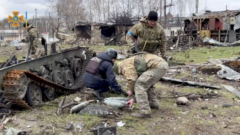 &copy; Reuters. Miembros del Servicio Estatal de Emergencias recogen municiones después de la retirada de Rusia del área, en Bucha, Ucrania, en esta imagen fija tomada de un video subido a un sitio web de redes sociales el 4 de abril de 2022. Servicio Estatal de Emerge