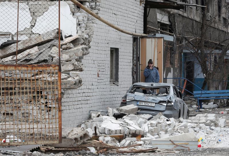 © Reuters. FILE PHOTO: A local resident stands near an apartment building damaged during Ukraine-Russia conflict in the southern port city of Mariupol, Ukraine April 4, 2022. REUTERS/Alexander Ermochenko/File Photo