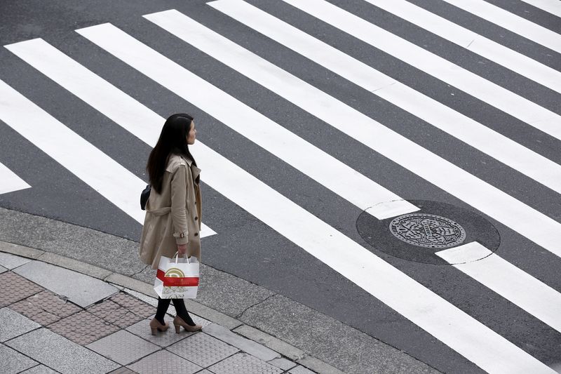 &copy; Reuters. FILE PHOTO: A woman holds a shopping bag as she waits at a pedestrian crossing in the Ginza district in Tokyo, Japan, March 24, 2016. REUTERS/Thomas Peter