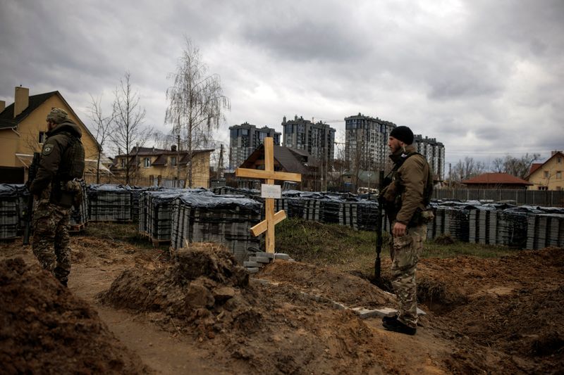 &copy; Reuters. Soldados ucranianos ao lado de cova em Bucha, na Ucrânia
06/04/2022
REUTERS/Alkis Konstantinidis