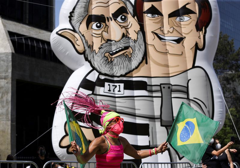 &copy; Reuters. FOTO DE ARCHIVO-Un manifestante agita banderas brasileñas junto a un muñeco hinchable que representa al presidente de Brasil, Jair Bolsonaro, y al expresidente brasileño Luiz Inacio Lula da Silva, durante una protesta para exigir la destitución del pr
