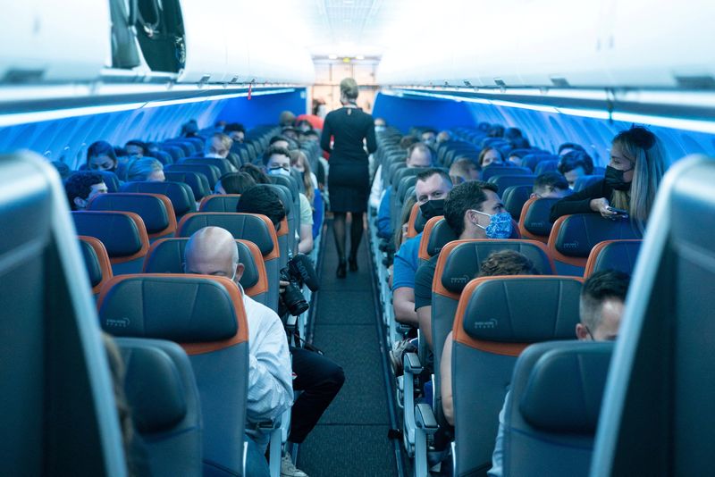 &copy; Reuters. FILE PHOTO: Passengers wearing protective masks are seen aboard before a JetBlue flight to London at JFK International Airport in the Queens borough of New York City, New York, U.S., August 11, 2021. REUTERS/Jeenah Moon/File Photo