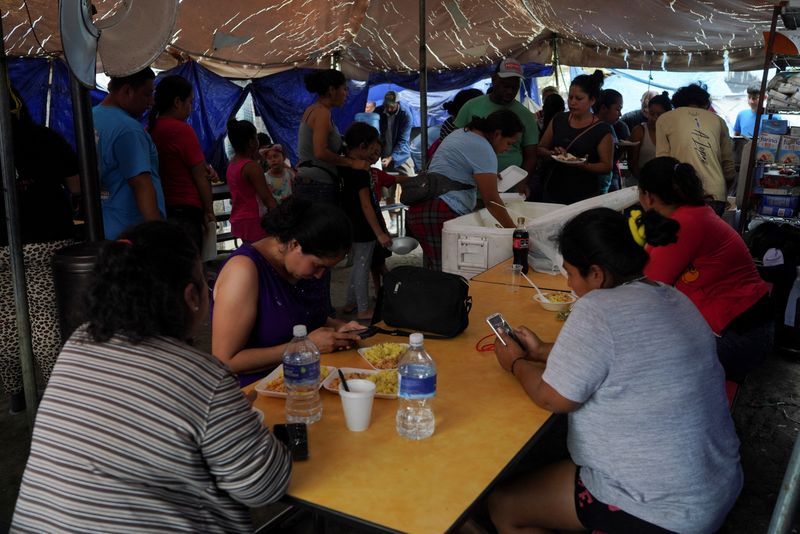 &copy; Reuters. FILE PHOTO: Migrants that were mostly sent back to Mexico wait to receive a meal prepared by other migrants that live at the encampment yards away from the border as they hope to be allowed into the U.S. when Title 42 is lifted, in Reynosa, Mexico, April 