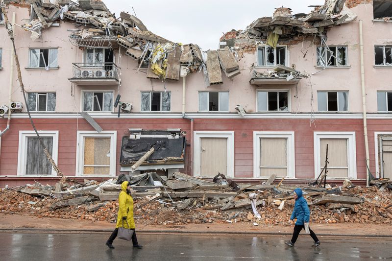 © Reuters. Women walk along a street in front of the destroyed Hotel Ukraine, as Russia's invasion of Ukraine continues, in Chernihiv, Ukraine, April 6, 2022. REUTERS/Marko Djurica 