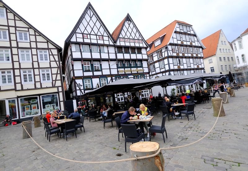 &copy; Reuters. FILE PHOTO: People eat outdoors in a cordoned-off area of a restaurant on the historic main market square of Soest, Germany, May 12, 2021.    REUTERS/Wolfgang Rattay