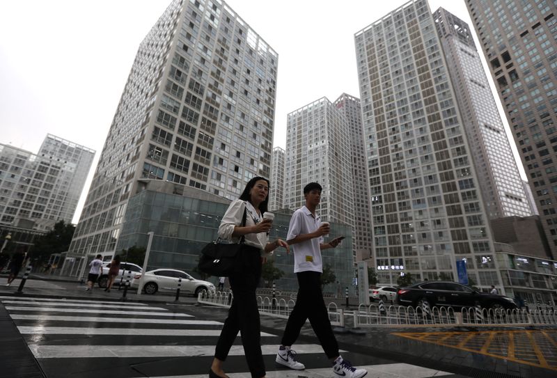 &copy; Reuters. People walk past an office compound in Beijing's Central Business District (CBD), China, July 13, 2021.   REUTERS/Tingshu Wang