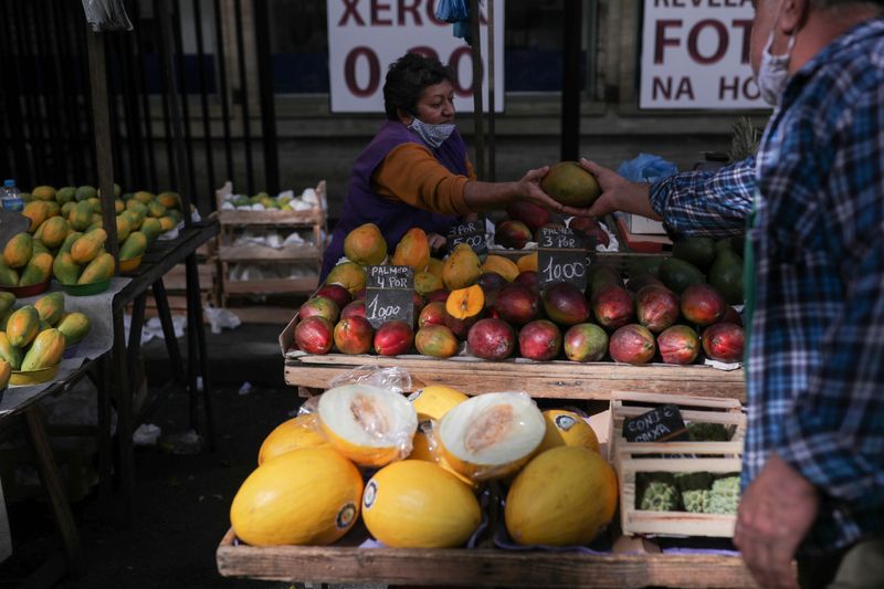 &copy; Reuters. Homem entrega manga a vendedora em mercado de rua no Rio de Janeiro
08/07/2021
REUTERS/Amanda Perobelli