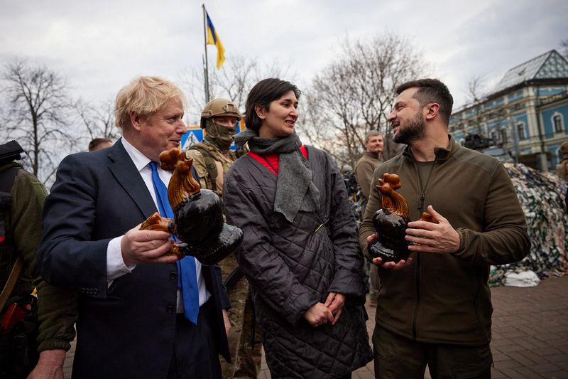 © Reuters. Ukraine's President Volodymyr Zelenskiy and British Prime Minister Boris Johnson hold ceramic roosters presented by local women, the same that were found among debris of residential building destroyed during Russia's invasion, in Borodianka town, central Kyiv, Ukraine April 9, 2022. Ukrainian Presidential Press Service/Handout via REUTERS 