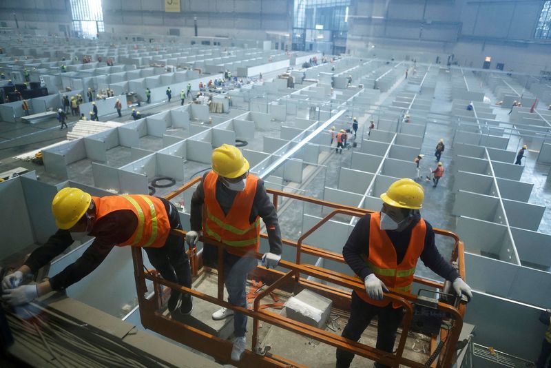&copy; Reuters. FILE PHOTO: Workers labour to convert the National Exhibition and Convention Center into a makeshift hospital for the coronavirus disease (COVID-19), in Shanghai, China April 7, 2022. Picture taken April 7, 2022. cnsphoto via REUTERS 