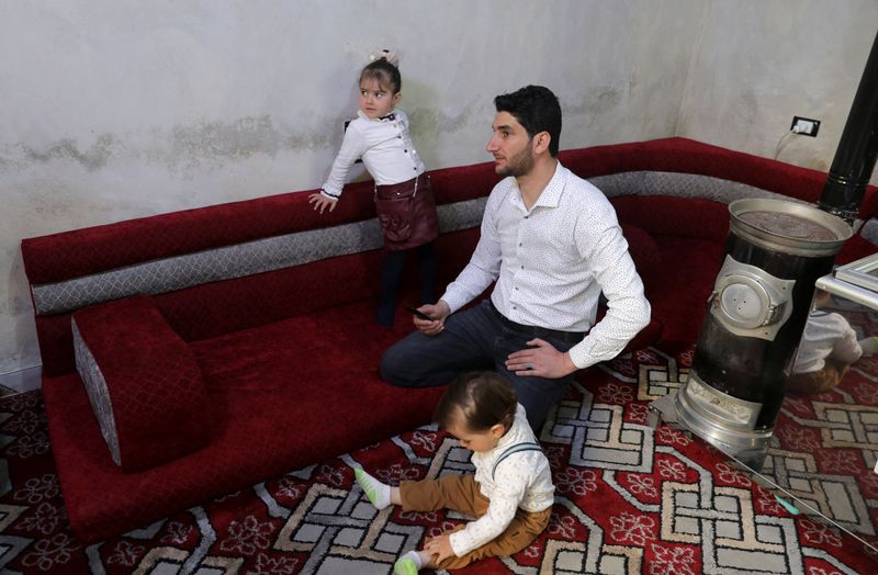 &copy; Reuters. عبد الحميد اليوسف نازح سوري يجلس هو وطفليه في منزله في محافظة إدلب بسوريا يوم الأول من أبريل نيسان 2022. تصوير: خليل عشاوي - رويترز.