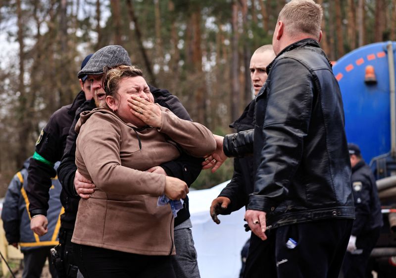 © Reuters. A mother reacts as police members exhume the body of her son, who according to the head of the village was killed by Russian soldiers, from a well at a fuel station in Buzova, Kyiv region, Ukraine April 10, 2022. REUTERS/Zohra Bensemra