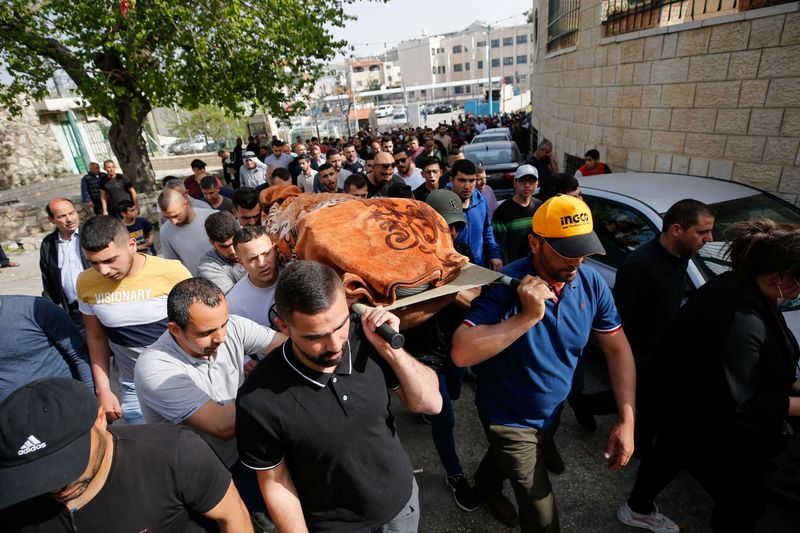 © Reuters. أشخاص يحملون امرأة فلسطينية قتلتها القوات الاسرائيلية في حوسان ببيت لحم في الضفة الغربية المحتلة يوم الأحد. تصوير:موسى قواسمة-رويترز.