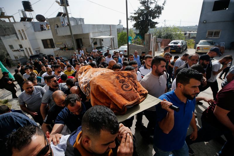 &copy; Reuters. Personas llevan el cuerpo de una mujer palestina en Husan el 10 de abril de 2022. REUTERS/Mussa Qawasma