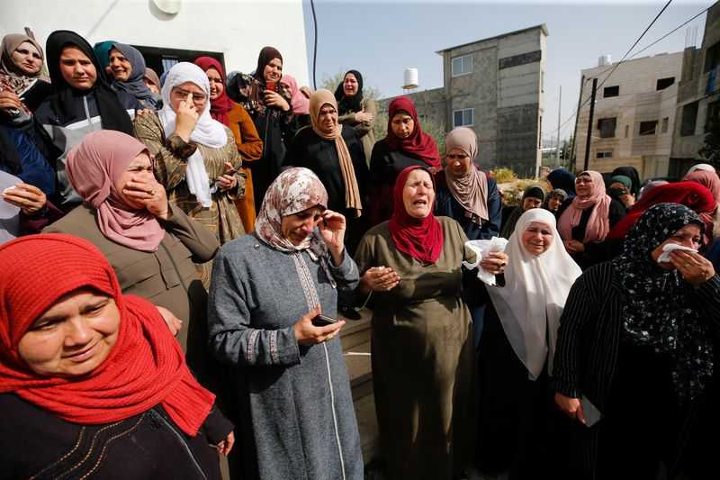 &copy; Reuters.  ４月１０日、 イスラエル軍はヨルダン川西岸で兵士を刃物で刺すなどしたパレスチナ人女性２人を射殺した。写真は射殺された女性の葬儀に参列した人々（２０２２年　ロイター/Mussa Qawasm