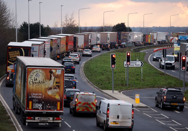 &copy; Reuters. FILE PHOTO: Trucks queue on the road leading to the Waterbrook Inland Border Facility, a temporary customs clearance centre set up in a truck stop in Ashford, Kent, Britain January 15, 2021. REUTERS/John Sibley