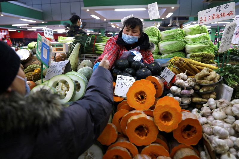 &copy; Reuters. Consumidora compra verduras em mercado em Pequim
14/01/2022
REUTERS/Tingshu Wang