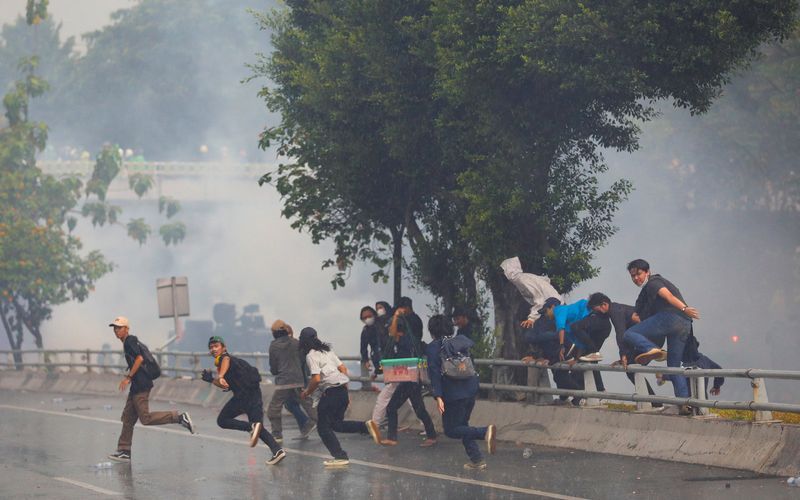 &copy; Reuters. متظاهرون يتفرقون بسبب إطلاق شرطة مكافحة الشغب الغاز المسيل للدموع خلال مظاهرات بالقرب من مبنى البرلمان في جاكرتا يوم الاثنين. تصوير: ويلي ك