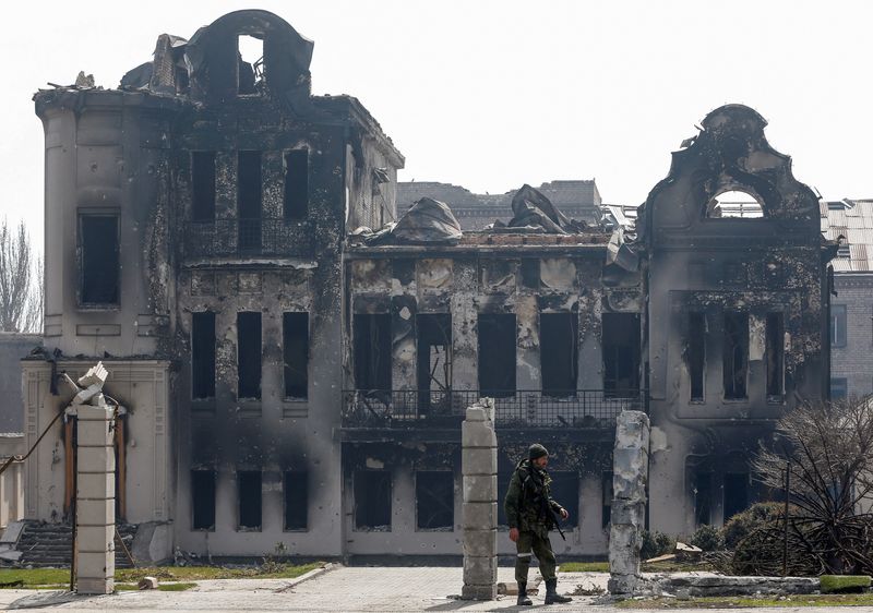 &copy; Reuters. Militar pró-Rússia em frente a prédio queimado em Mariupol
10/04/2022
REUTERS/Alexander Ermochenko