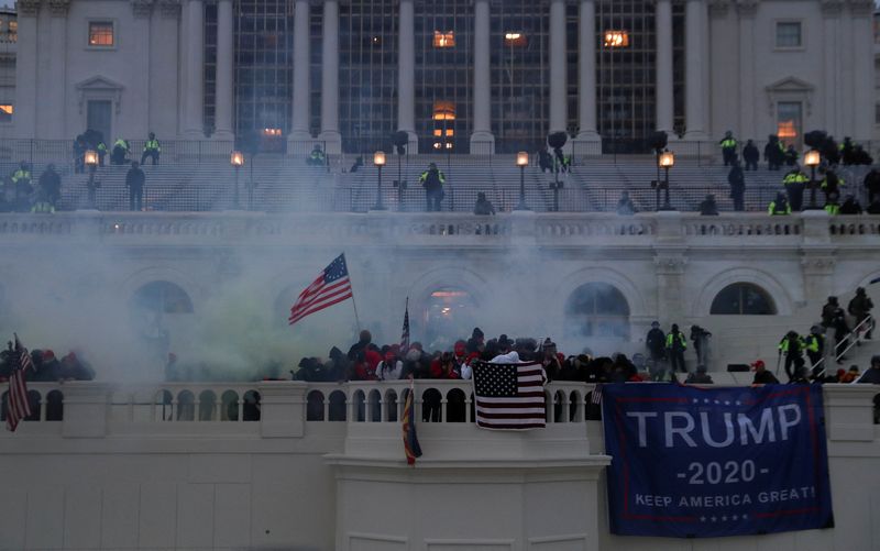 &copy; Reuters. FILE PHOTO: Supporters of U.S. President Donald Trump react to tear gas during a clash with police officers in front of the U.S. Capitol Building in Washington, U.S., January 6, 2021. REUTERS/Leah Millis/File Photo