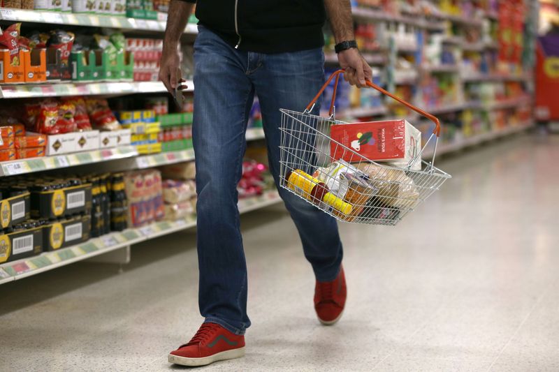 &copy; Reuters. FILE PHOTO: A shopper carries a basket in a supermarket in London, Britain April 11, 2017. REUTERS/Neil Hall